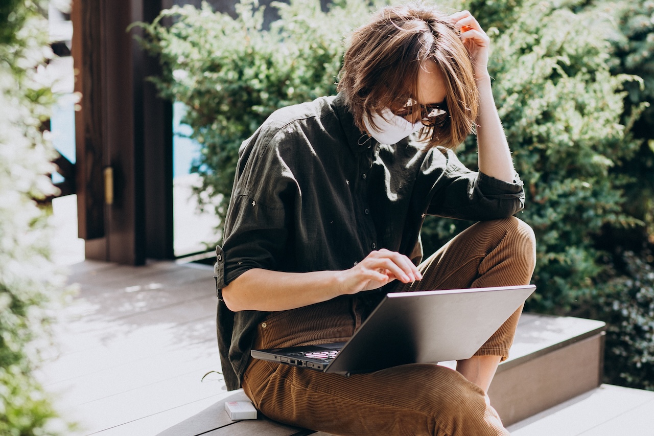 Young Business Woman Working On Computer From Home In Mask